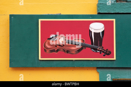 Illustration d'un violon et de pinte de Guinness pub sur un mur, Dingle, comté de Kerry, Munster, Irlande. Banque D'Images