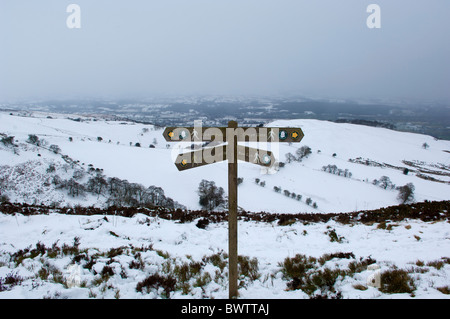 Un hiver enneigé scène montrant un doigt post le sentier Offas Dyke nr Moel Gwm. Vallée de Clwyd visible à distance Banque D'Images