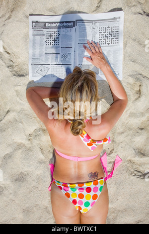 Sur la plage d'Amadores Sunbather dans Gran Canaria, lire le journal Banque D'Images