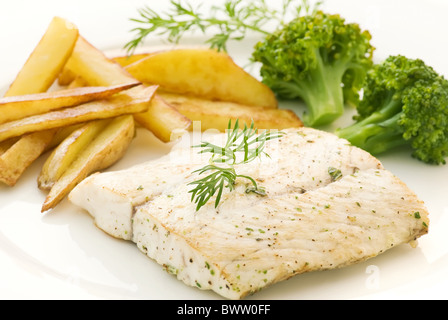 Filet de loup de mer avec brocoli et puces que gros plan sur une plaque blanche Banque D'Images