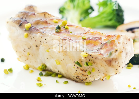 Poisson perroquet steak avec des légumes et des frites comme gros plan sur une plaque blanche Banque D'Images