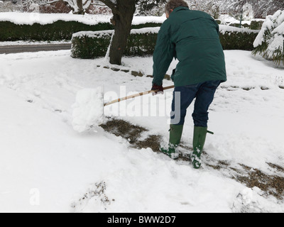 L'homme avec la neige Pelle à neige après de fortes chutes de neige dans le Sud Est de l'Angleterre Banque D'Images