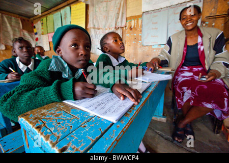 L'enseignant et d'élèves de bidonvilles de Mathare à Maji Mazuri centre et école, Nairobi, Kenya Banque D'Images
