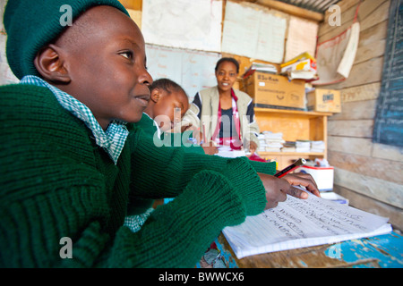 L'enseignant et d'élèves de bidonvilles de Mathare à Maji Mazuri centre et école, Nairobi, Kenya Banque D'Images
