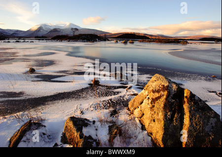 La recherche à travers un frozen lochan nah-achlaise des sommets de la chaîne de montagnes Blackmount en hiver. Banque D'Images