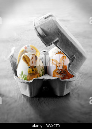 Peint à la main les oeufs de poule avec design traditionnel lapin de Pâques dans un œuf fort comme un cadeau de Pâques Banque D'Images