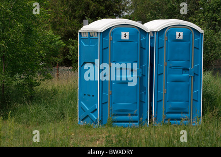 Cabines Toilettes mobiles bleu dans une scène en plein air Banque D'Images