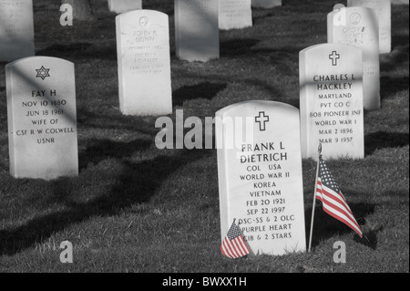 Les petits drapeaux américains debout à côté d'une pierre tombale dans le Cimetière National d'Arlington, à Arlington, en Virginie. Banque D'Images