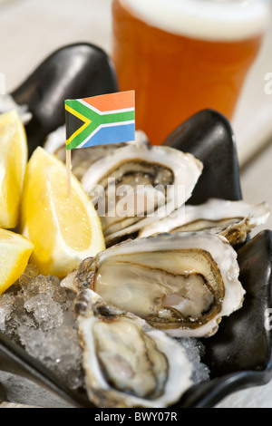 Des huîtres avec du citron et une pinte de bière de Mitchell comme servi par le restaurant Oyster Catcher à Knysna, Afrique du Sud. Banque D'Images