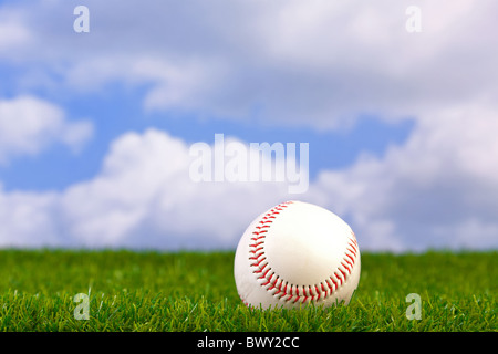 Photo d'un base-ball sur herbe avec fond de ciel. Banque D'Images