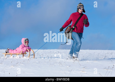 Femme fille enfant tirant sur le traîneau en bois en hiver paysage, Dobel, Forêt Noire, Gerrmany Banque D'Images