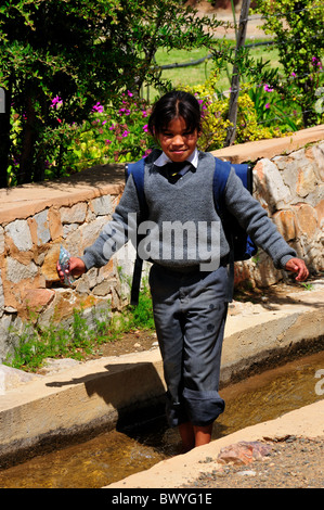 Une fille de l'école joue dans le conduit d'eau. Prince Albert, Afrique du Sud. Banque D'Images