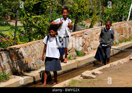Trois enfants de l'école joue dans le conduit d'eau. Prince Albert, Afrique du Sud. Banque D'Images