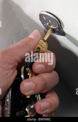 Tourner à la main une clé dans une serrure de porte interne Banque D'Images