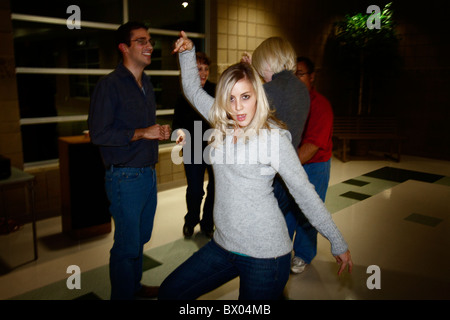 Une femme frappe un silly posent lors d'une fête. Banque D'Images