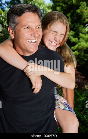 Caucasian father giving daughter piggyback ride Banque D'Images