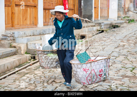 Femme portant des paniers de biens, de Yunnanyi, Province du Yunnan, Chine Banque D'Images