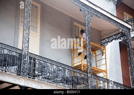 Un travailleur n'entretien sur une maison dans le quartier français de La Nouvelle-Orléans, Louisiane. Banque D'Images