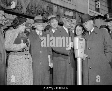 Vintage photo prise en 1938 d'une foule regardant la première nickel est inséré dans de nouveaux horodateurs à Washington DC. Banque D'Images