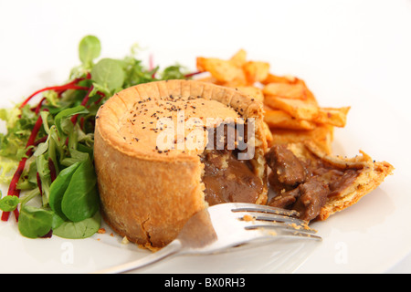 Un steak pie, servi avec des chips de pomme de terre frites et une salade verte. Banque D'Images