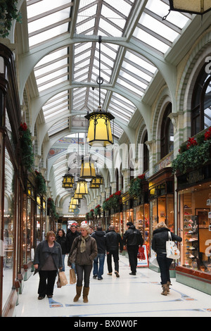 Royal Arcade, Norwich, Norfolk, England, UK. Clients mystères de commerçant de l'époque victorienne en verre couvert avec petites boutiques traditionnelles Banque D'Images