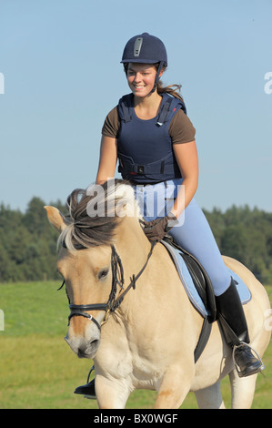 Jeune portant un corps protecteur sur dos d'un cheval norvégien Banque D'Images