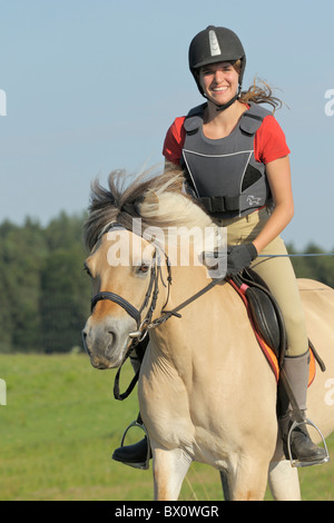 Jeune portant un corps protecteur sur dos d'un cheval norvégien Banque D'Images