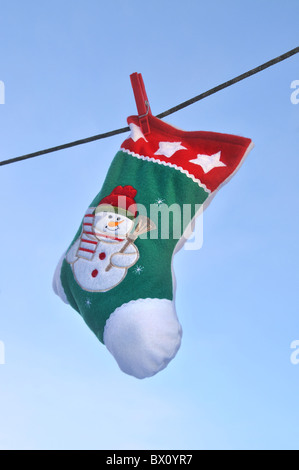 Un bas de Noël en peluche accroché à un lave-ligne. Banque D'Images