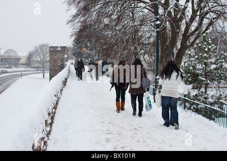 Les étudiants en direction de la gare le long de la neige a couvert les murs de la ville de Canterbury, Décembre 2010 Banque D'Images