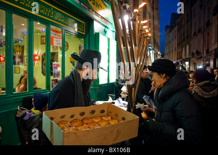 Paris, France, rabbins juifs célébrant la fête religieuse annuelle, Hanoukkah, distribuant de la nourriture dans la rue dans le Marais la nuit, les traditions juives anciennes Banque D'Images
