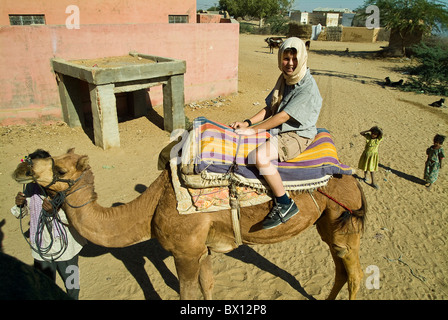 Garçon européen assis sur un chameau dans le désert de Thar, près de Bikaner, Rajasthan, India Banque D'Images