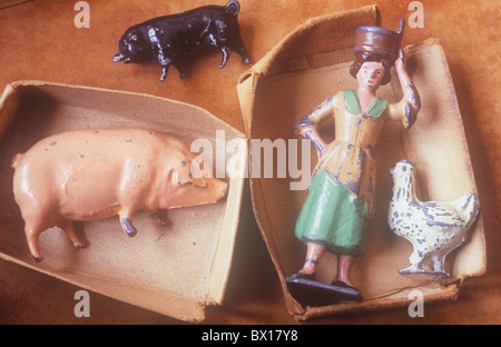 Close up de deux petits bacs carte avec des modèles de plomb métal rayé femme avec godet de lait sur la tête de poulet et de porc plus Banque D'Images