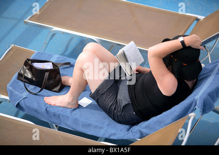 Femme lisant un livre à bord d'un paquebot de croisière Banque D'Images