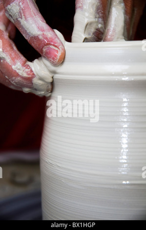 Une femme européenne potter de son atelier d'argile de formes sur un tour de potier. Libre de ses mains Banque D'Images