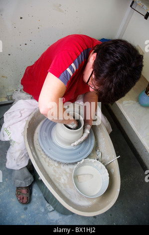 Une femme européenne potter dans son atelier travaille sur un tour de potier Banque D'Images