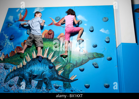 Deux enfants l'escalade sur un mur intérieur Banque D'Images