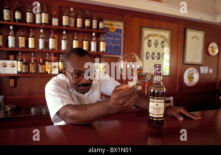 L'origine africaine bar alcool barmen Barbade Bridgetown bouteille verre verrerie homme boissons dégustation Banque D'Images