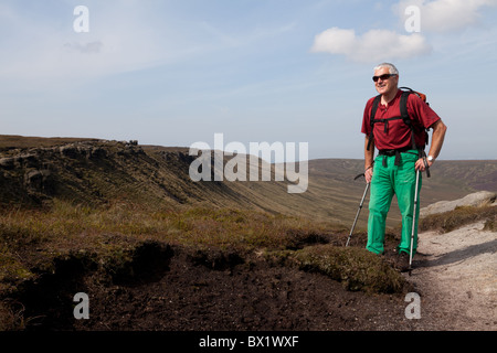 Un homme Walker sur le bord nord de la Kinder Scout plateau, Pic Noir, Derbyshire, Royaume-Uni Banque D'Images