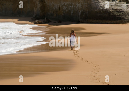 Femme marche pieds nus dans le sable sur une plage vide, Great Ocean Road, Victoria, Australie Banque D'Images