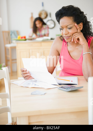 Black mère regardant factures mensuelles Banque D'Images