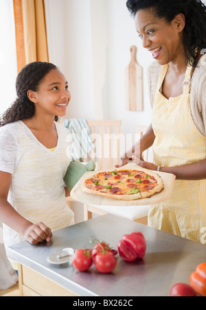 Mère et fille de préparer la pizza pour le dîner Banque D'Images