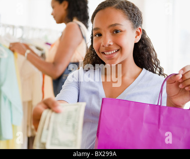 Mixed Race girl remise en argent magasin de vêtements Banque D'Images