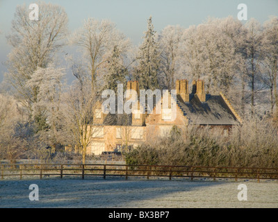 Une maison de campagne dans Barton Bendish Norfolk entouré d'arbres couverts de givre et le soleil casting shadows en décembre. Moins 7C Banque D'Images