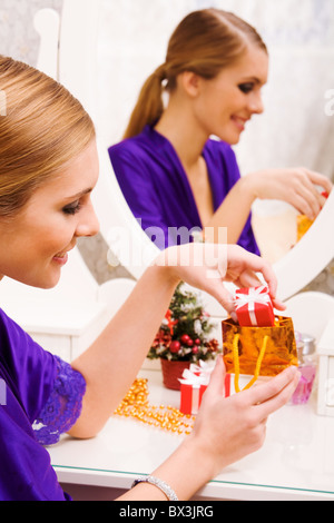 Portrait of happy girl putting petit paquet d'or en coffret Banque D'Images