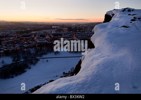 Regarder sur Édimbourg au coucher du soleil sur la neige couverts Salisbury Crags Banque D'Images