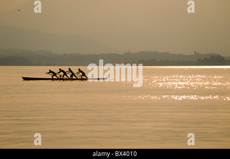 Quatre hommes l'aviron dans le style vénitien connu sous le nom de "Voga alla Veneta", sur le lac de Garde, Italie Banque D'Images