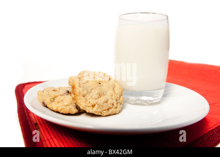 Une assiette de cookies aux pépites de chocolat et un grand verre de lait Banque D'Images