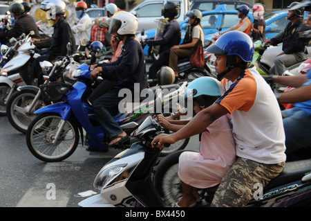 Conducteur de scooter en attente à un feu rouge à Bangkok Banque D'Images