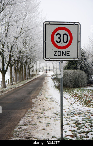 Vue d'un 30km/h panneau dans un petit village allemand à l'heure d'hiver. Banque D'Images