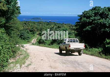 Pick up truck voyageant sur une route de terre menant vers l'océan avec hat island dans l'arrière-plan, l'île d'Efate, Vanuatu. Banque D'Images